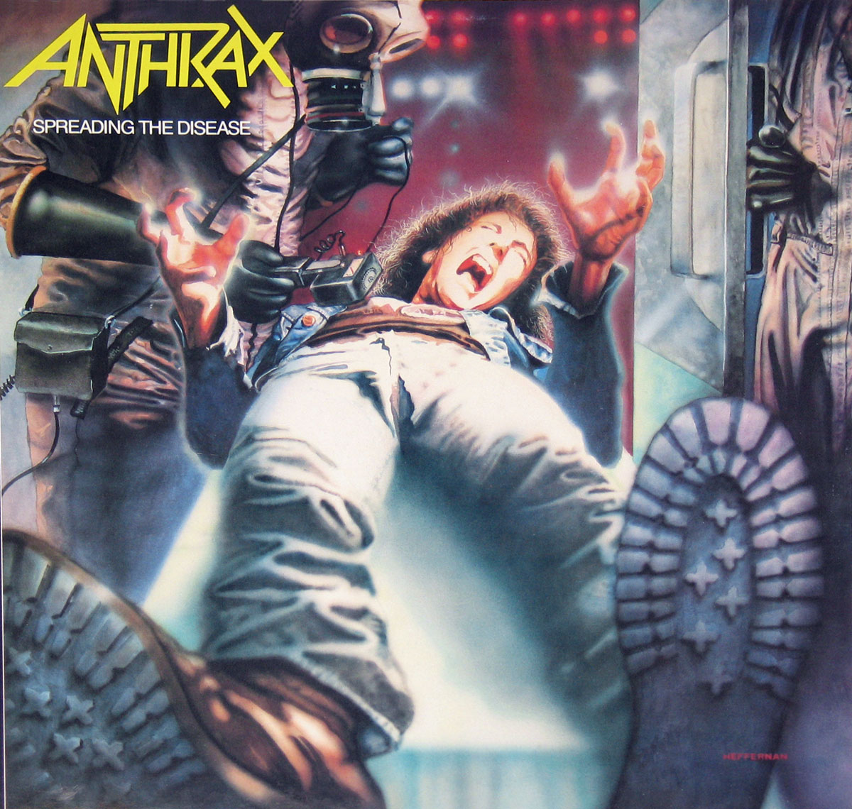 Album cover of Anthrax's 'Spreading the Disease'. A man in a denim jacket is being restrained by two figures in gas masks and protective suits while another figure in a hazmat suit looms near a metallic door. The man's face shows a screaming expression, and his body is forcefully pulled as if being dragged or experimented on. The foreground prominently features the soles of boots.